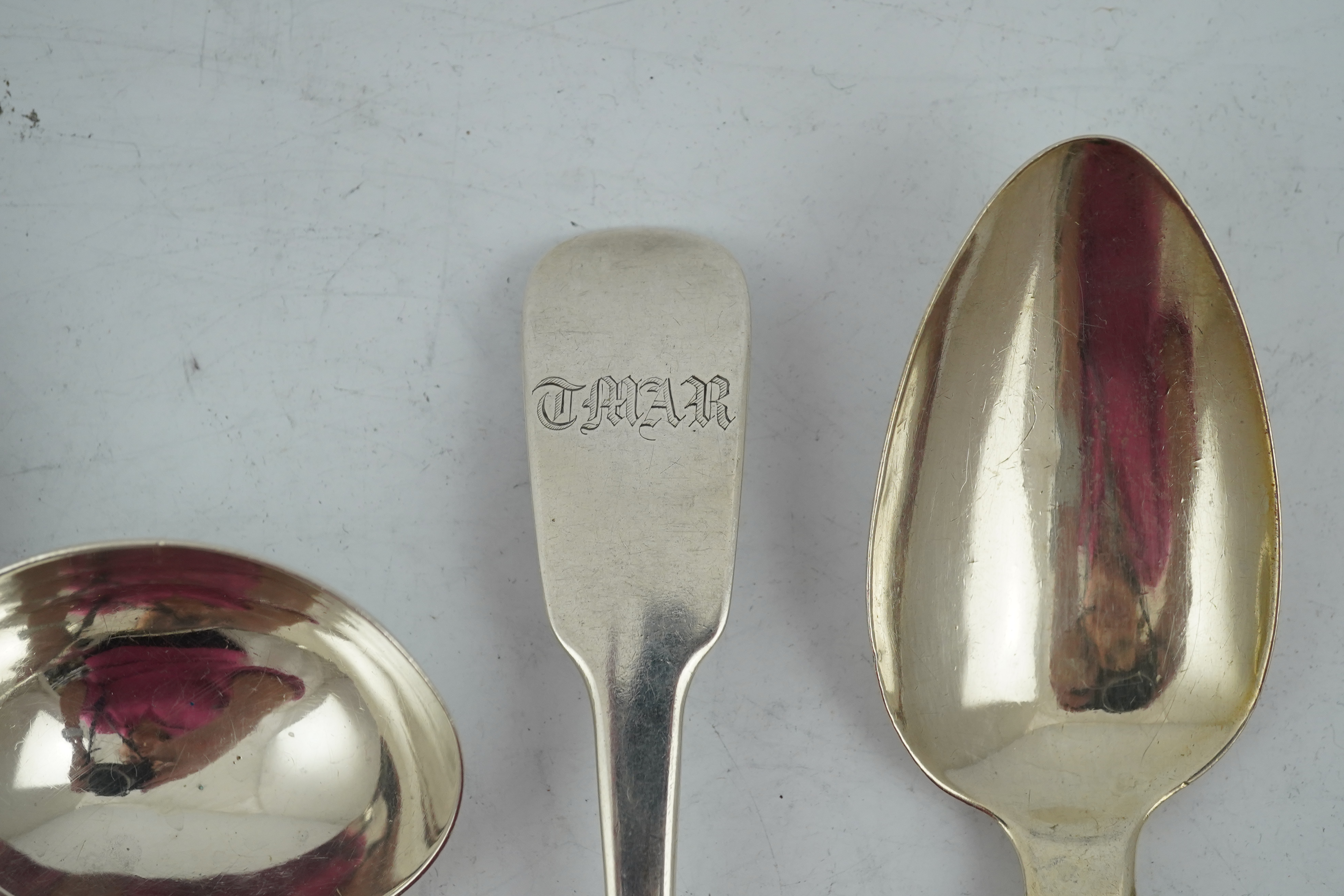 A matched set of seven late Victorian silver table spoons by Goldsmiths & Silversmiths Co Ltd (5) and Francis Higgins (2), London, 1894, together with a similar silver sauce ladle, two earlier silver table spoons and a W